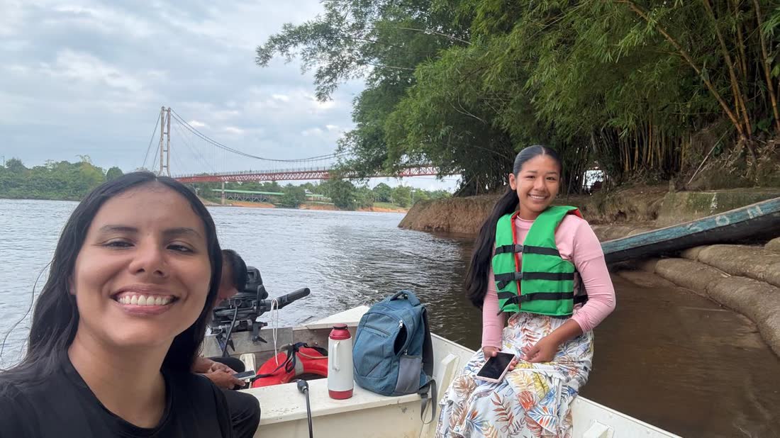 Dos integrantes del equipo navegando el río en lancha, con chaleco salvavidas